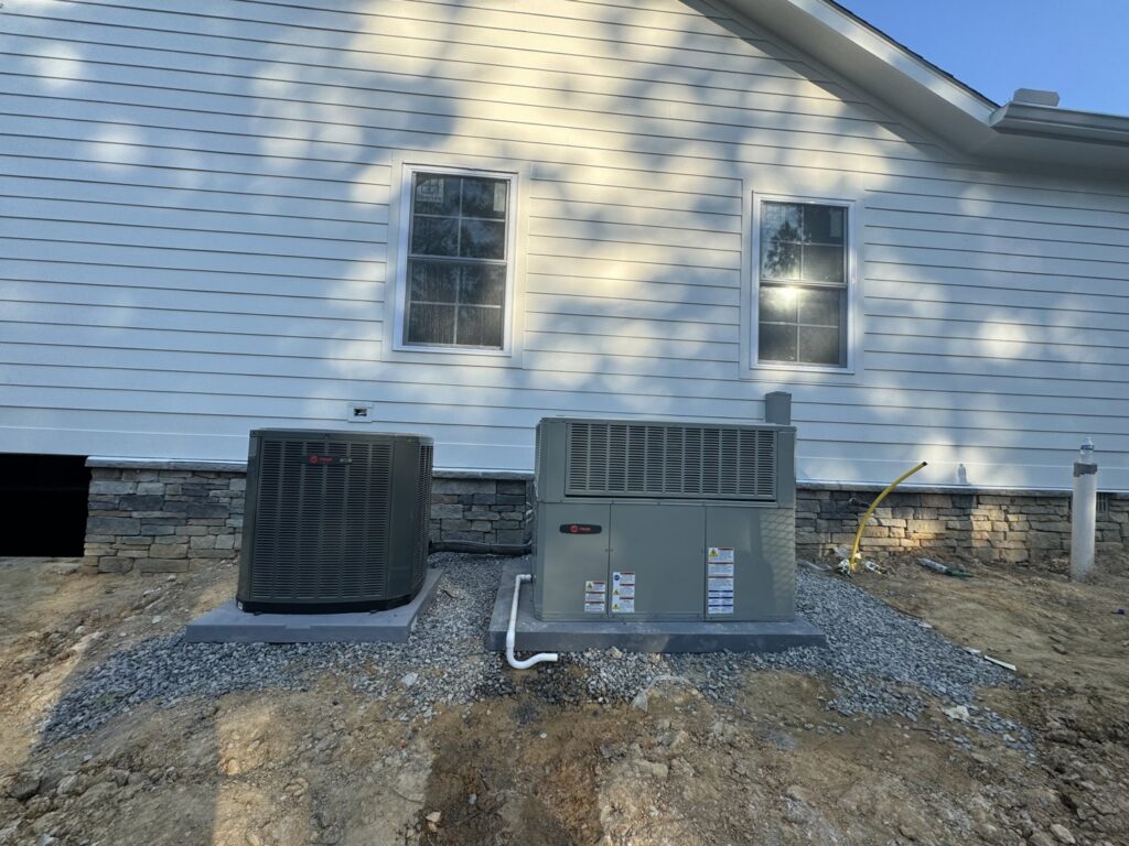 Two Trane outdoor HVAC condenser units installed next to a residential building by Federal Heating & Cooling in Dresden, OH.