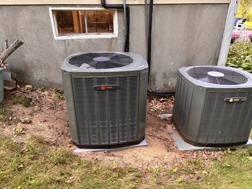 Two Trane HVAC condenser units installed outside a building by Wood's Heating Service in Tiverton, RI