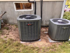 Two Trane HVAC condenser units installed outside a building by Wood's Heating Service in Tiverton, RI