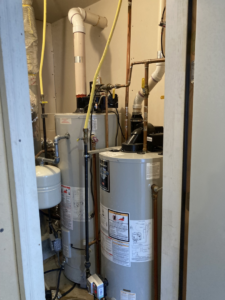 Two water heaters and associated piping installed in a utility closet by Advanced Heating & Cooling in St. Cloud, MN.