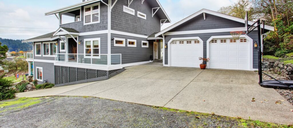 A modern home featuring two white panel garage doors installed by Overhead Door Company of Evansville in Evansville, IN.