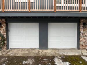 Two white panel garage doors installed side-by-side on a modern home by Remarkable Door Company in Spokane, WA.