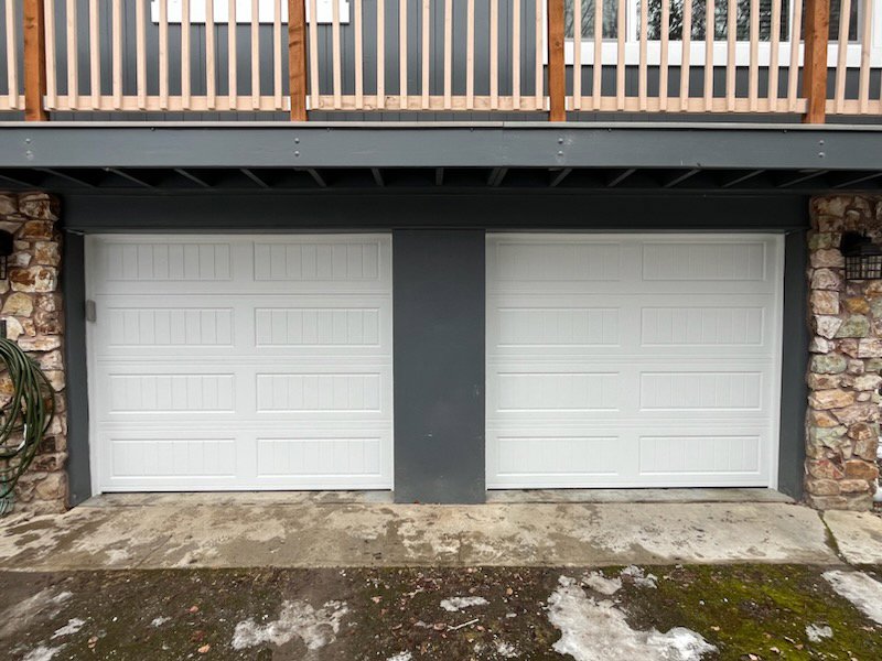 Two white panel garage doors installed side-by-side on a modern home by Remarkable Door Company in Spokane, WA.