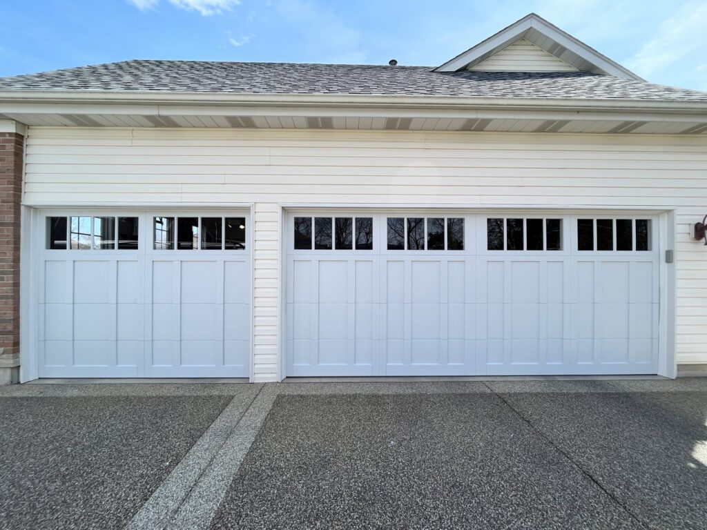 Two white residential garage doors with top panel windows installed by 314 Overhead Doors in O'Fallon, MO.