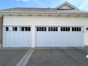 Two white residential garage doors with top panel windows installed by 314 Overhead Doors in O'Fallon, MO.