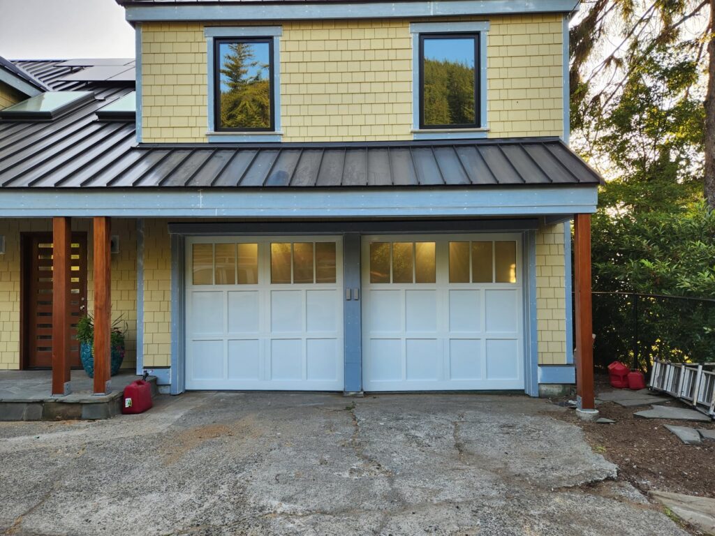 Two white traditional-style garage doors with window panels installed by Overhead Door Company of Everett, Inc in Everett, WA.