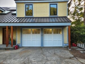 Two white traditional-style garage doors with window panels installed by Overhead Door Company of Everett, Inc in Everett, WA.