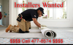 Two workers installing new carpet in a residential room for Freeport Carpet Ltd in Freeport, The Bahamas.