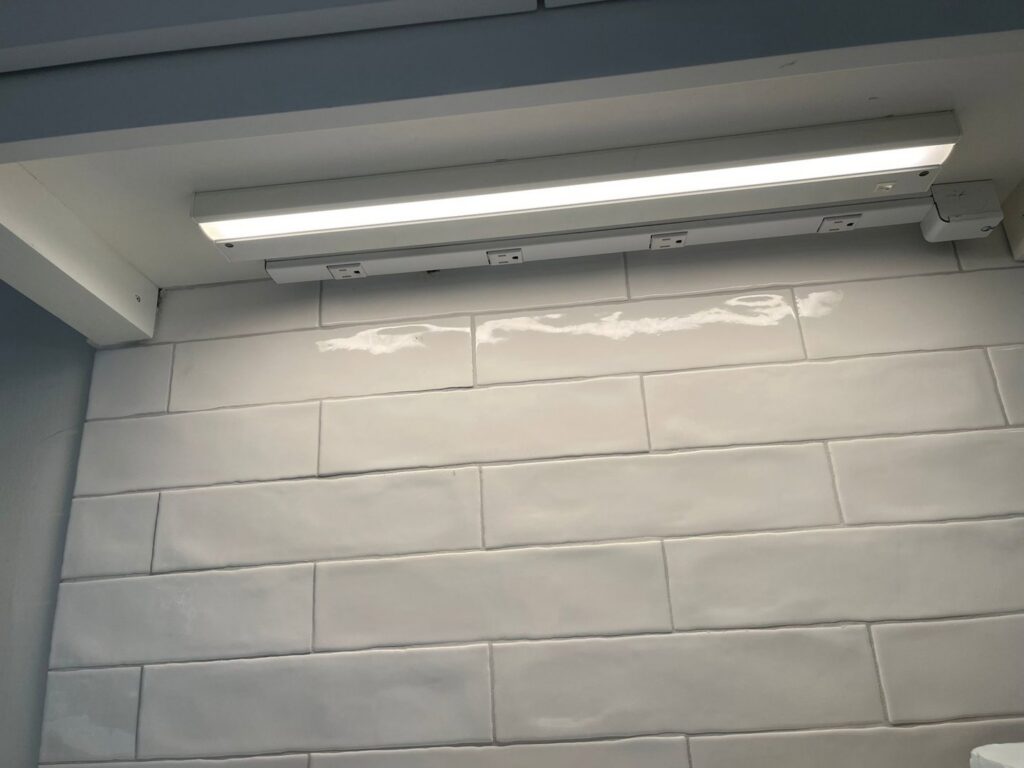Close-up of under-cabinet lighting and integrated outlets installed by J&M Electrical Services in Stockbridge, GA.