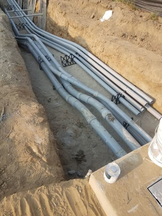 Underground electrical conduits laid in a trench for installation by Ant Power Electric in Tacoma, WA.