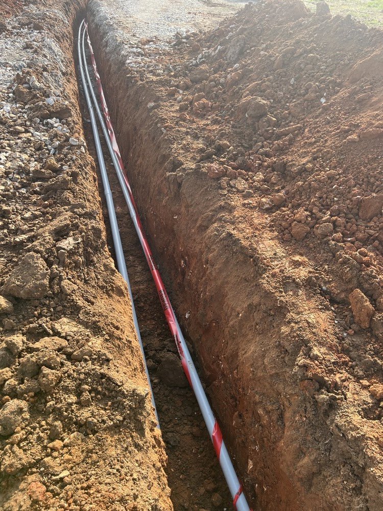 Underground electrical conduit installation in a trench by Blevens Electric LLC in Bowling Green, KY