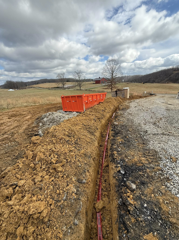 Underground electrical conduit being laid in a trench by Power House Electrical LLC in Johnson City, TN