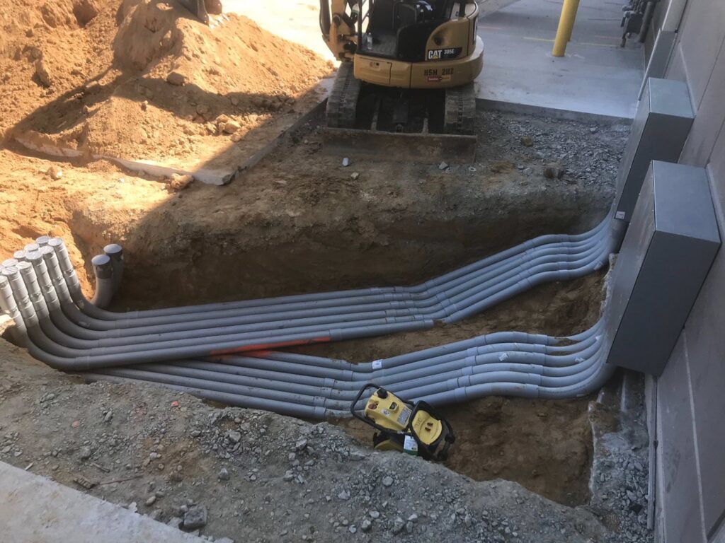 Underground electrical conduit installation in a trench at a job site by RD Graham Electric, LLC in Greensboro, NC.