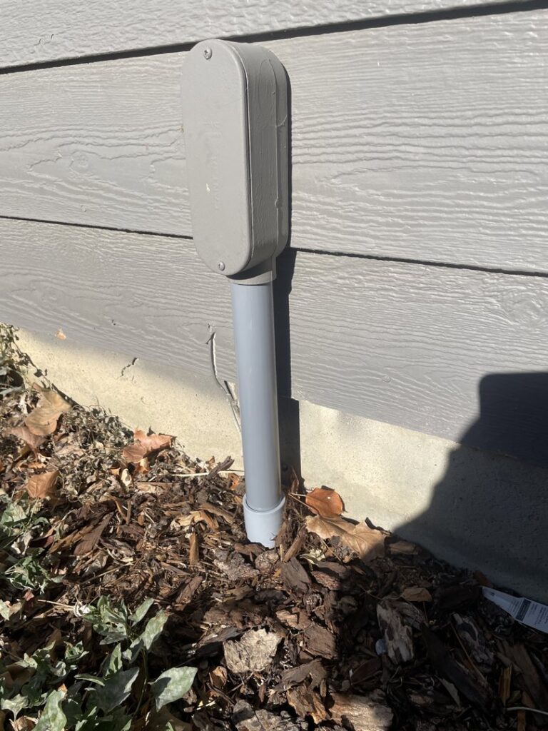 Underground electrical conduit installation leading to an outdoor electrical box by Wilson Electrical Contractors in Orlando, FL.