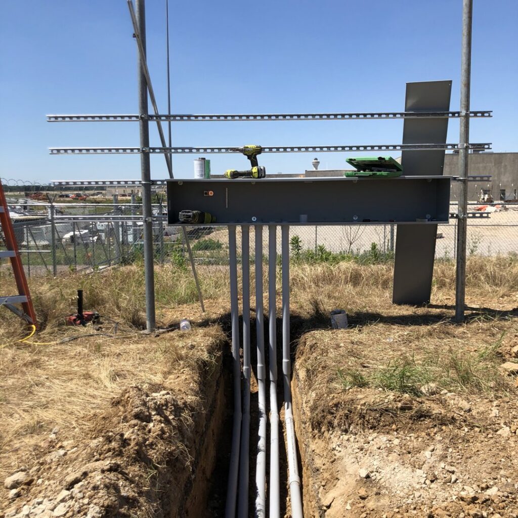 Underground electrical conduits being installed in a trench leading to an electrical panel structure by Rush Electric Memphis, TN.