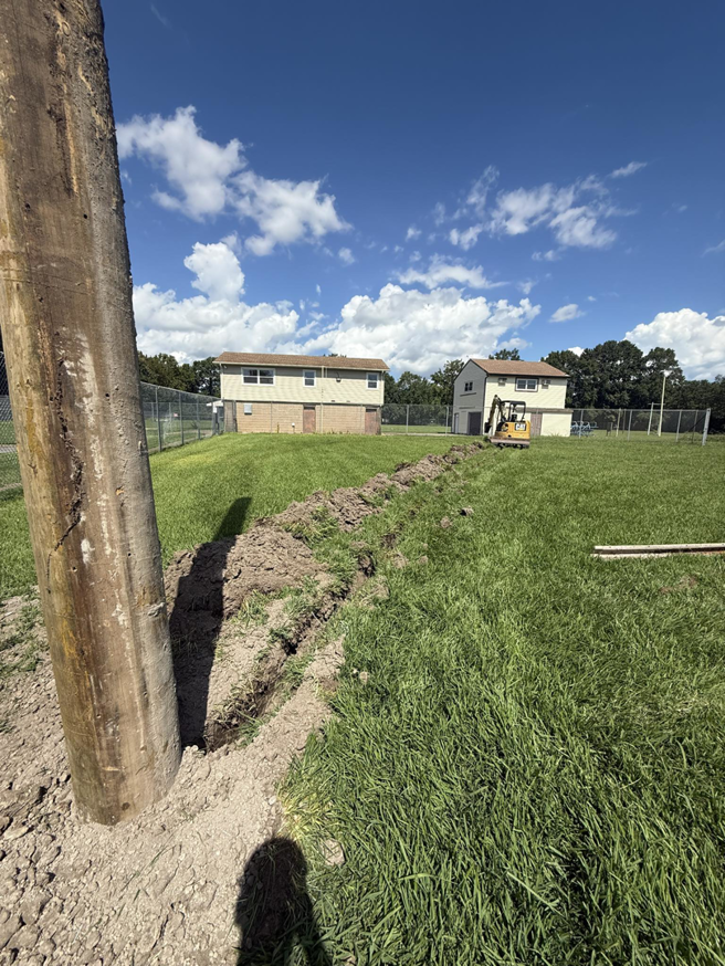 A trench dug for underground electrical wiring next to a utility pole by Relay Electric, LLC in Suffolk, VA.