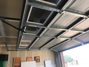 An interior view looking up at the frame and windows on the underside of an open garage door, installed by Johns Garage Doors in Tucson, AZ.