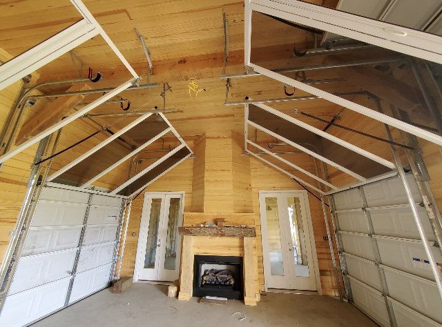 A unique interior garage door installation with two doors and a central fireplace, completed by Superior Garage Door & Repairs in Lafayette, LA.