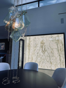 A unique glass chandelier and a backlit wall feature installed by Focal Electric Company in Dallas, TX.