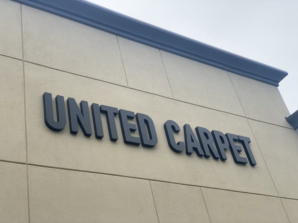 The exterior sign for United Carpet, clearly displaying the business name in Rochester, NY.