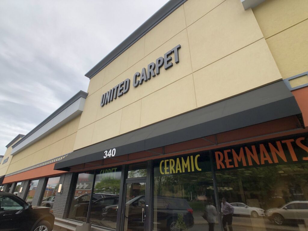The exterior storefront of United Carpet, showing the business name and address 340 in Rochester, NY.