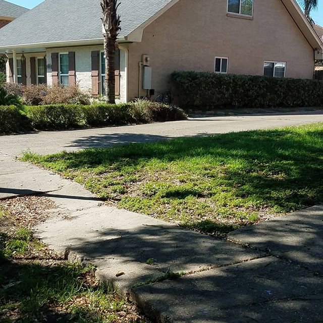An unkempt and patchy lawn with weeds, showing a property in need of care from Mcfaith Lawn Care LLC in New Orleans, LA.
