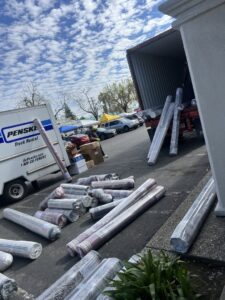 Workers unloading rolled carpets from a Penske rental truck for Afghan turk carpet online in Sacramento, CA.
