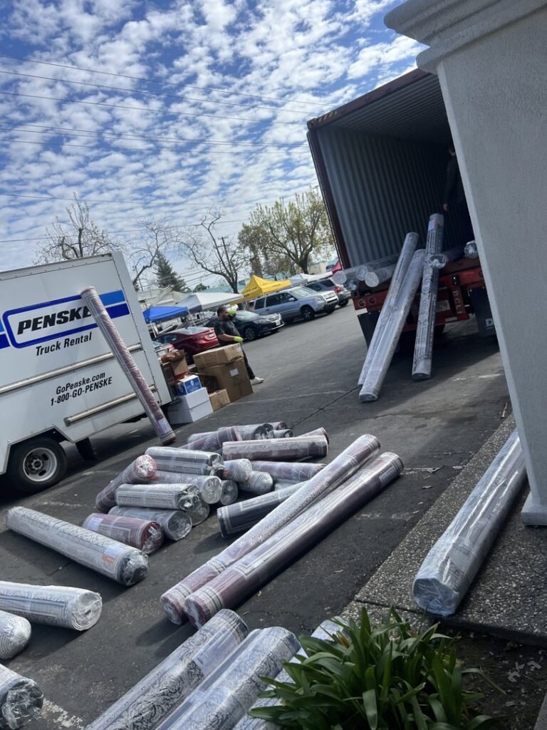 Workers unloading rolled carpets from a Penske rental truck for Afghan turk carpet online in Sacramento, CA.