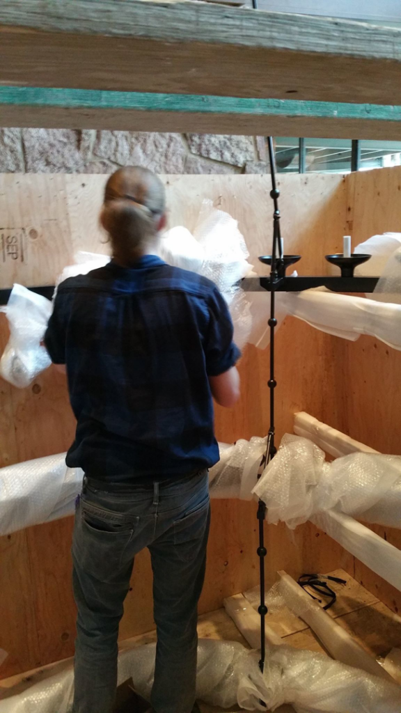 A technician unpacking components of a large light fixture for installation by Rockhill Electrical Systems in Colorado Springs, CO.