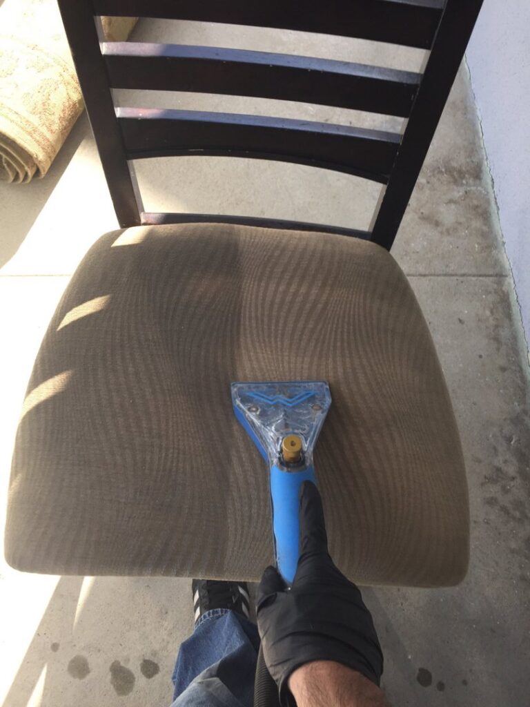 A professional cleaning an upholstered chair at Mystic Steam Carpet & Upholstery Cleaning in Long Beach, CA