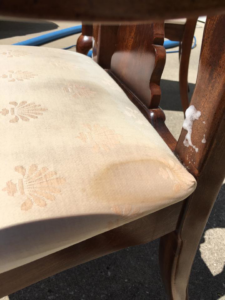 An upholstered dining chair with a brown stain and cleaning foam during a job by Erich's Carpet Care in Blue Springs, MO