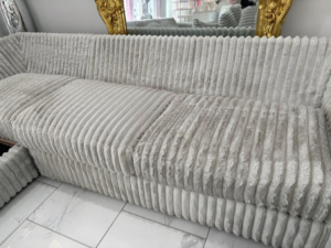 An upholstered sofa showing a clear before and after cleaning result by White Diamond Carpet Cleaners in Baton Rouge, LA.