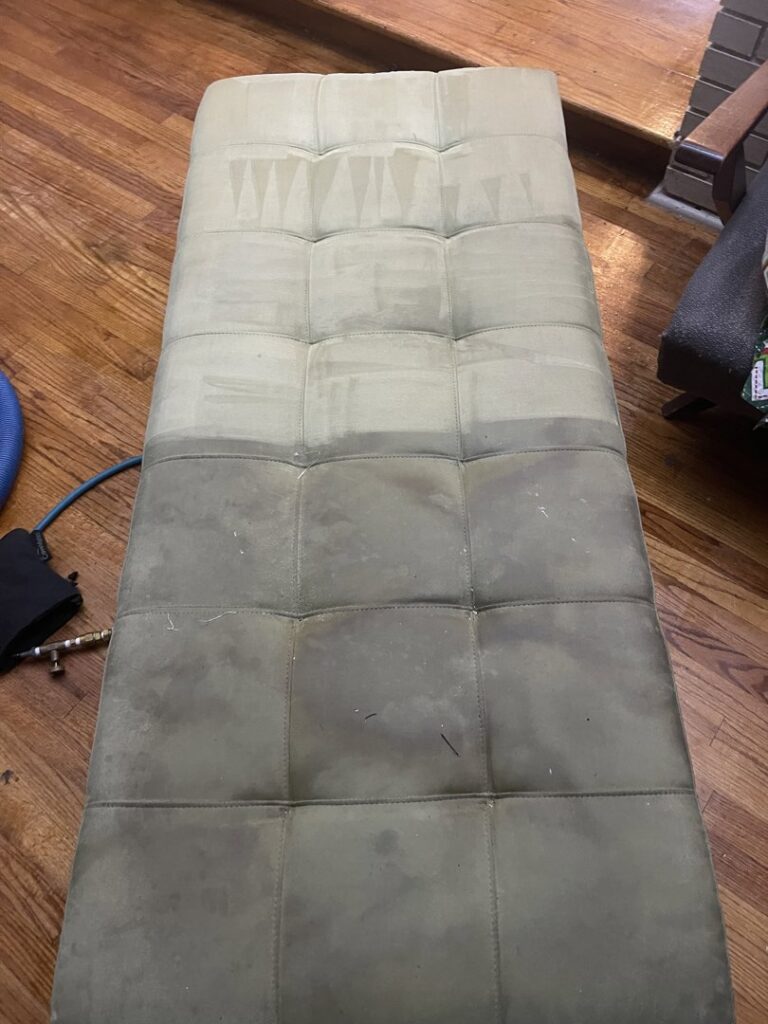 An upholstered bench, half cleaned to show the before and after, by Affordable carpet cleaning CO LLC in Montgomery, AL.