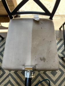 An upholstery cleaning job showing a chair cushion half cleaned by Premium Carpet & Upholstery in Fort Collins, CO