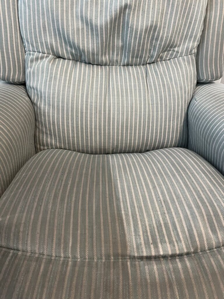 An upholstered chair showing a clear difference between the cleaned and uncleaned sections by Steamworks Carpet and Upholstery Cleaners in Matthews, NC.