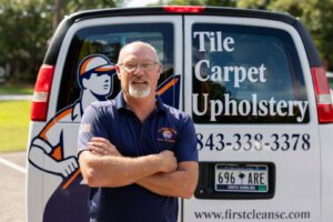 A technician from First Clean SC cleaning a blue armchair's upholstery in North Charleston, SC.