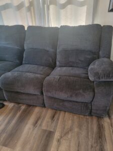 A dark grey sectional sofa showing before and after upholstery cleaning by Klein Chem-Dry in Cedar Rapids, IA.