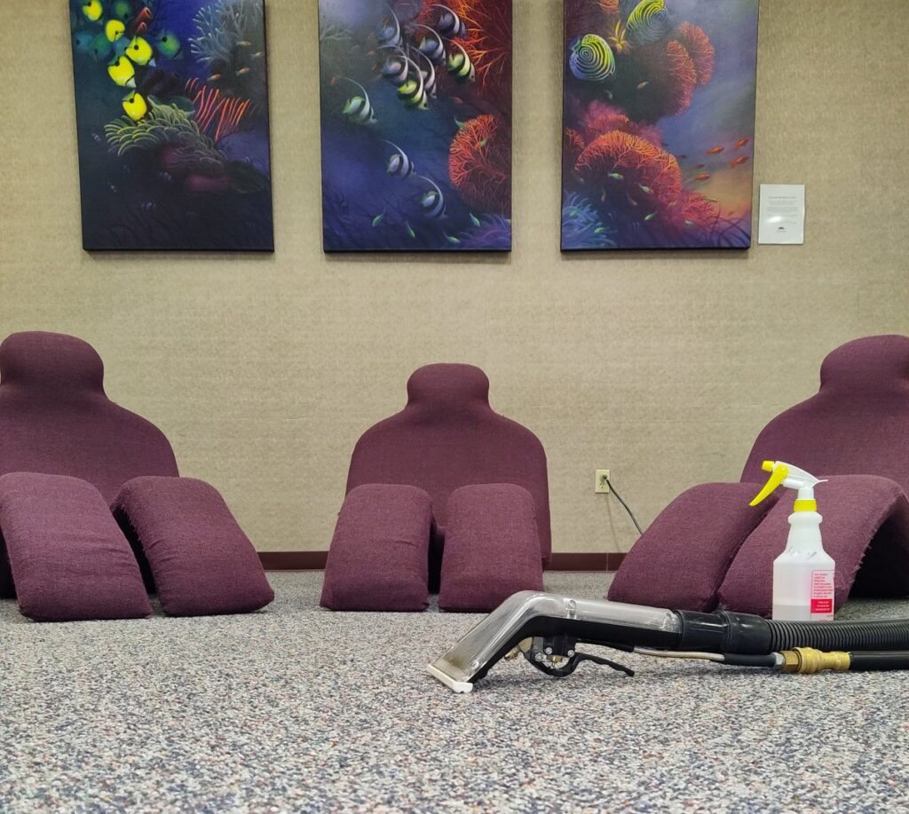 Upholstery cleaning in progress with a cleaning tool and spray bottle on a carpet by 765 Custom Cleaners in Lafayette, IN.