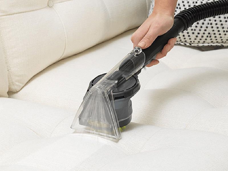 A hand cleaning upholstery with a specialized tool, offered by Nashville Carpet Cleaning in Madison, TN.