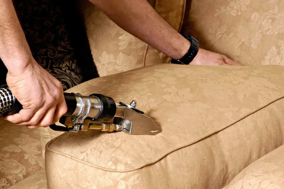 A professional upholstery cleaning service being performed on a sofa by Pichey's Clean Rite in Flint, MI.