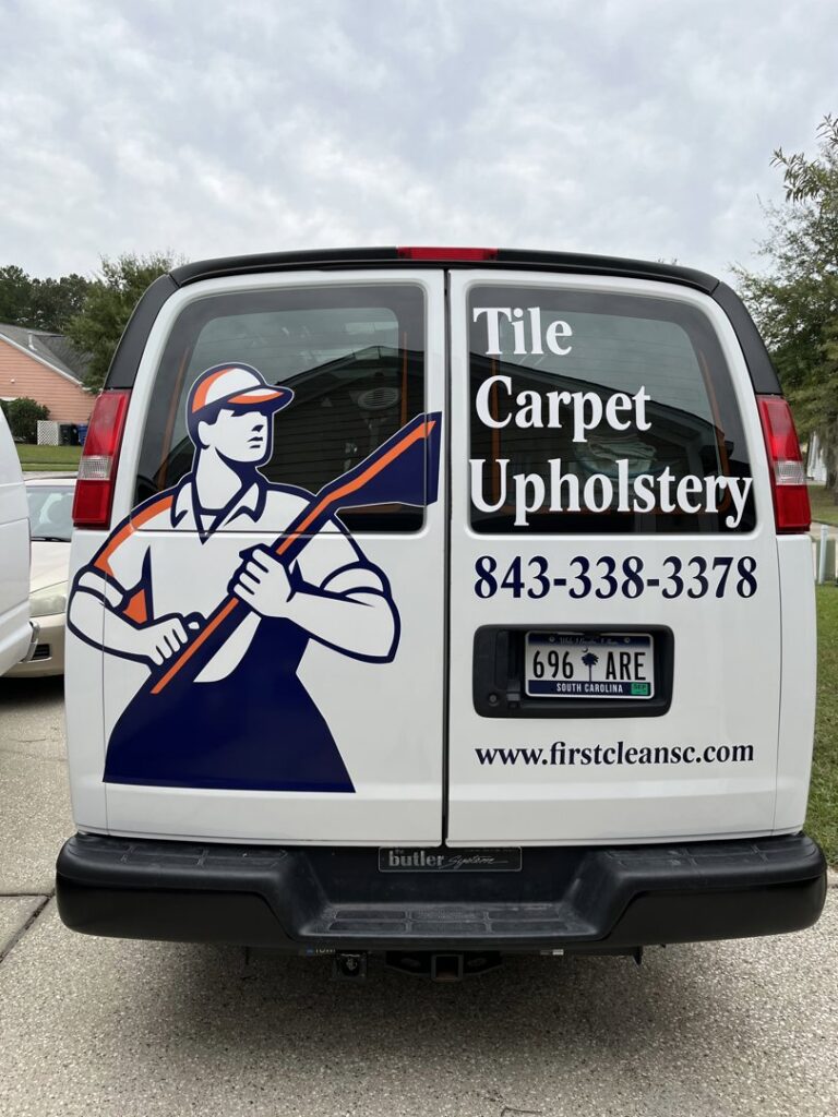 A smiling technician from First Clean SC cleaning sofa upholstery in North Charleston, SC.
