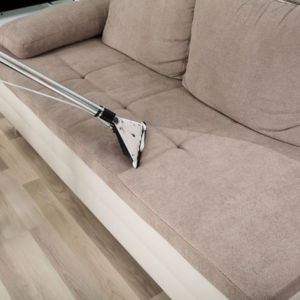 Professional cleaning tool on a sofa, showing a clear before and after line, by Seminole Carpet Cleaning in Tallahassee, FL