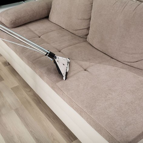 Professional cleaning tool on a sofa, showing a clear before and after line, by Seminole Carpet Cleaning in Tallahassee, FL