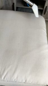 A close-up view of a white upholstered cushion being professionally cleaned by Chem-Dry Nona in Orlando, FL.