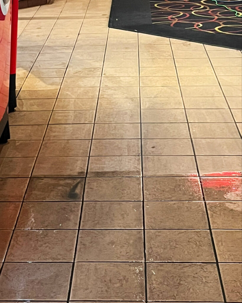 A professional using an upholstery cleaning tool on a sofa cushion by Atlanta Top Force Carpet Cleaning in Roswell, GA.
