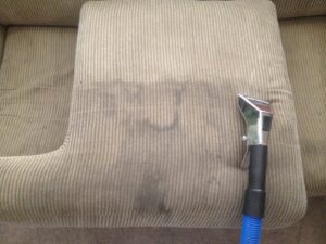 An upholstery cleaning tool actively cleaning a dirty sofa cushion for Ecodry Carpet Cleaning Las Vegas, NV.