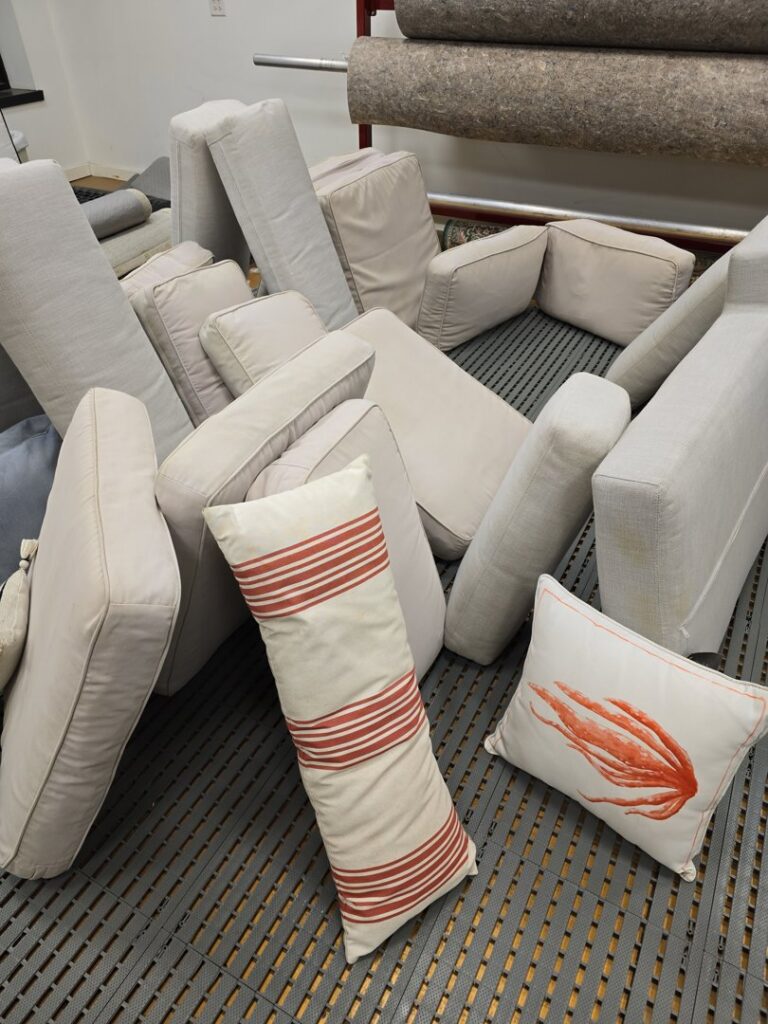 A pile of sofa and chair cushions ready for professional upholstery cleaning at Personal Touch Carpet Cleaning in Chicago, IL.