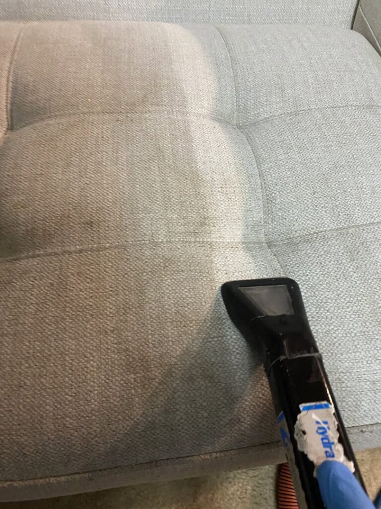 Upholstery sofa cleaning in progress, showing a clear before and after difference, by Treo General Services of North Carolina LLC in Durham, NC.