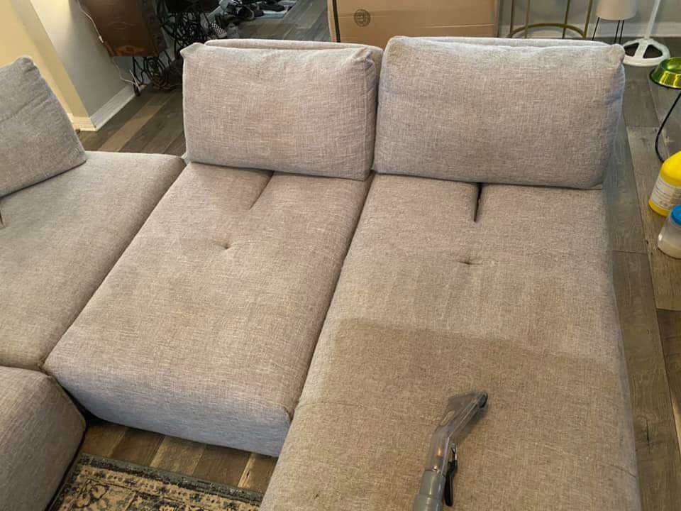 An upholstery cleaning tool cleaning a light-colored sofa sectional by D&H Anytime Carpet Cleaning LLC in Mobile, AL.