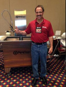 A technician from Green Bay Carpet Cleaning using a handheld tool for upholstery or stair cleaning in Green Bay, WI.